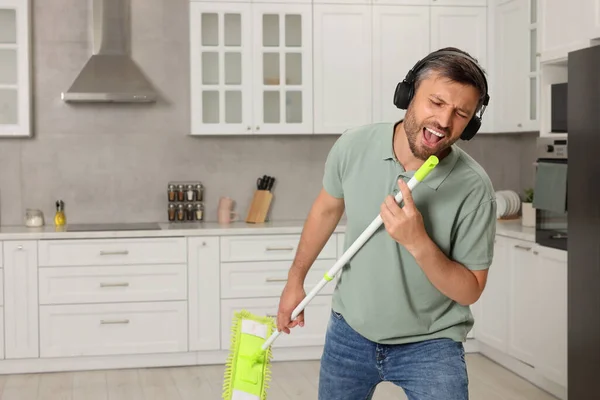 Ευτυχισμένος Άντρας Ακουστικά Σφουγγαρίστρα Τραγουδάει Ενώ Καθαρίζει Στην Κουζίνα Χώρος — Φωτογραφία Αρχείου