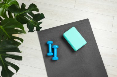 Egzersiz paspası, yoga bloğu ve halterler içeride, üst manzara.
