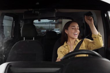 Radyo dinliyordum. Arabadaki müzikten hoşlanan güzel bir kadın, ön camdan manzaralı.