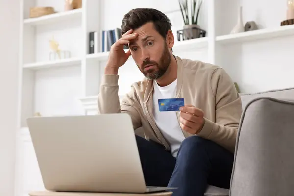 Zdenerwowany Człowiek Kartą Kredytową Pobliżu Laptopa Domu Uważaj Oszustwo — Zdjęcie stockowe