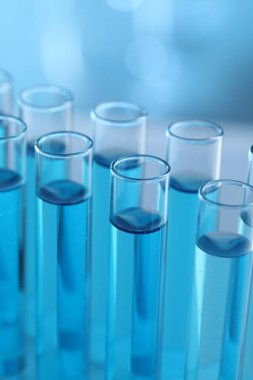 Laboratuvarda açık mavi sıvıyla test tüpleri, yakın plan.
