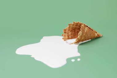 Yeşil arka planda erimiş dondurma ve gofret konisi.