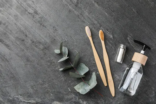 stock image Flat lay composition with bamboo toothbrushes on black table, space for text