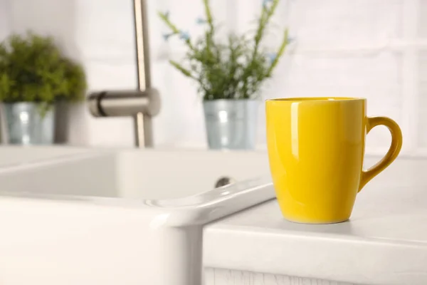 One ceramic mug on light countertop in kitchen, space for text