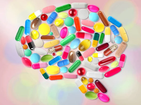 Brain shape made of different pills on colorful background, top view