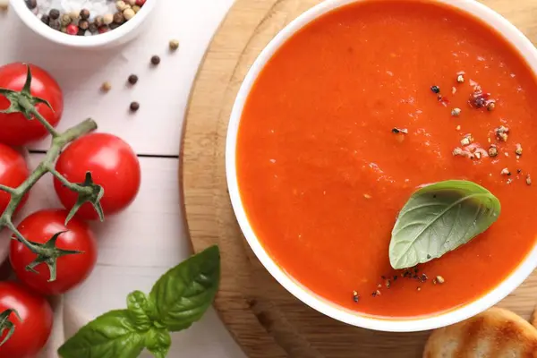 Stock image Delicious tomato soup served on white wooden table, flat lay