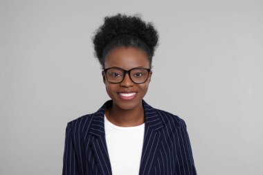 Açık gri arka planda güzel bir genç kadının portresi