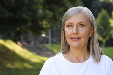 Güzel mutlu son sınıf kadınının portresi açık havada, mesaj için yer var.