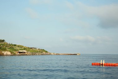 Mavi gökyüzünün altında deniz ve kıyı manzarası