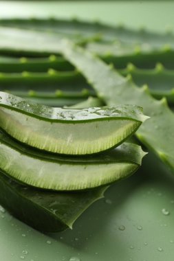 Yeşil arkaplanda taze aloe vera parçaları, yakın plan