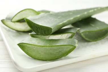 Taze aloe vera parçaları beyaz masada, yakın plan.