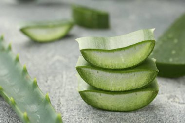Gri masada taze aloe vera parçaları, yakın plan.