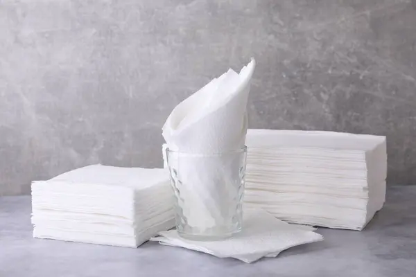 Clean paper towels and tissues on grey table