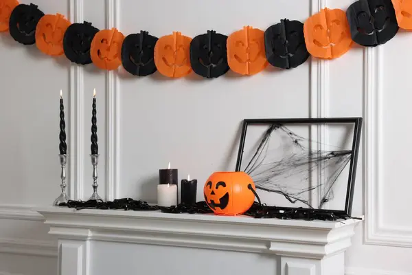 Different Halloween decor near white wall indoors