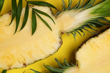 Sarı arka planda olgun ananas ve yeşil yapraklar düzleşir.