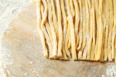 Masada çiğ makarna ve un var, yakın plan. Metin için boşluk