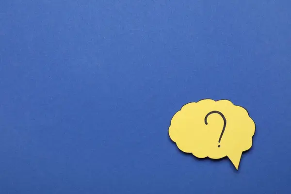 Paper speech bubble with question mark on blue background, top view. Space for text