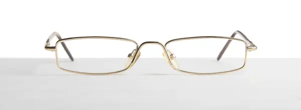 Óculos Elegantes Com Moldura Metal Mesa Contra Fundo Branco Fotografia De Stock