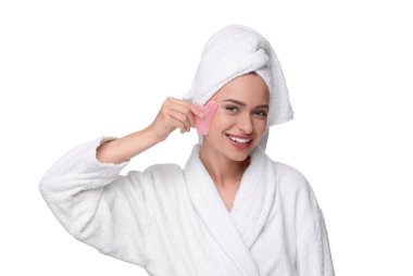 Beyaz üzerine izole gül kuvars gua aleti ile yüzüne masaj yapan genç kadın