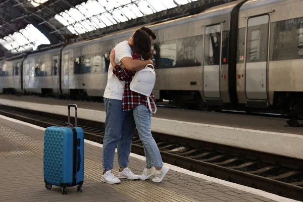 Long-distance relationship. Couple hugging on platform of railway station