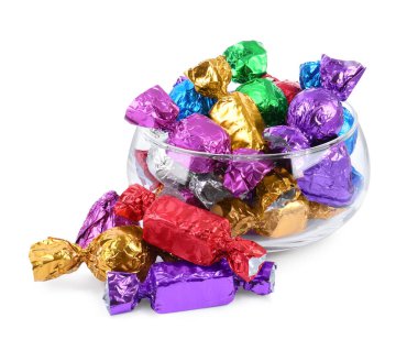 Beyaza izole edilmiş renkli ambalajlarla bir sürü lezzetli şekerle dolu bir kase.