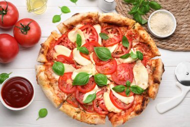 Lezzetli Caprese pizzası beyaz ahşap masada, düz yerde.
