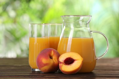 Lezzetli şeftali suyu ve ahşap masada taze meyveler.