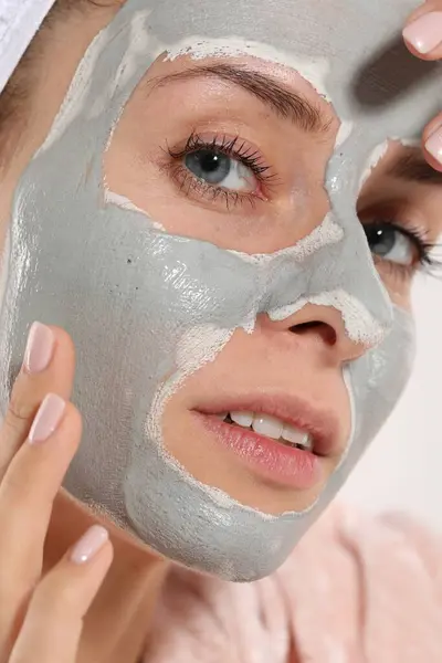 Woman with face mask on white background, closeup. Spa treatments