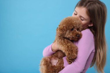 Açık mavi arka planda şirin köpek yavrusu olan küçük bir çocuk, mesaj için yer var. Sevimli hayvan
