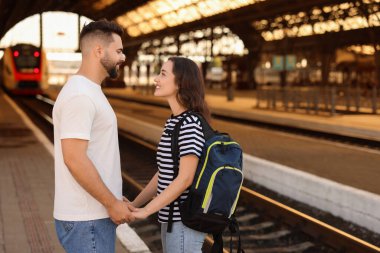 Uzun mesafeli ilişki. Tren istasyonu platformunda güzel bir çift