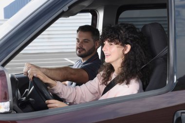 Ehliyet kursu. Araba sürüş eğitmeniyle ders sırasında öğrenci