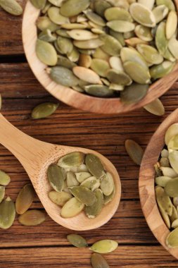 Kabuklu kabak tohumlu kase ve kaşık ahşap masa, düz yatıyordu