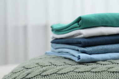 Sıralama ve düzenleme. Yatağın içinde farklı katlanmış giysiler yığını, metin için boşluk