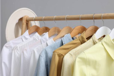 Gri arka planda farklı tarz gömleklerle dizilin, yakın plan. Giysileri düzenleme