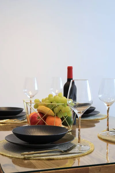 Bottle of wine and fruits served for dinner indoors, space for text