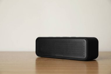 Tahta masada siyah portatif bir bluetooth hoparlör. Ses ekipmanları