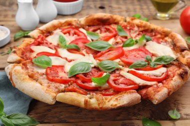 Lezzetli Caprese pizzası ahşap masada, yakın plan.