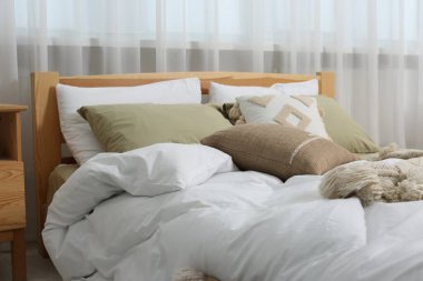 Yumuşak yastıkları ve odada yorganı olan büyük, rahat bir yatak. Ev tekstili