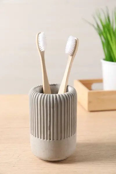 Bamboo toothbrushes in holder on wooden table