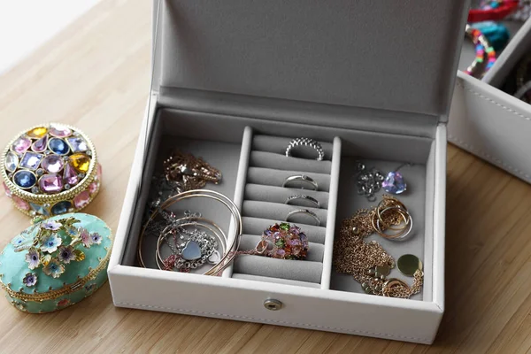 Jewelry boxes with many different accessories on wooden table