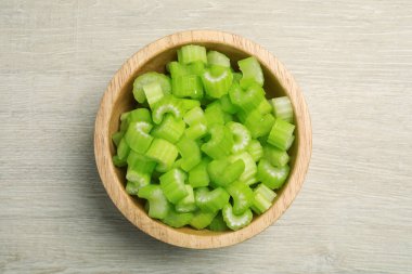 Taze kesilmiş kereviz sapları ahşap masada, üst manzara.