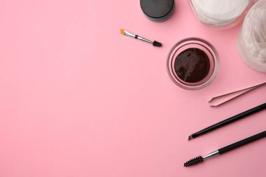 Pembe arkaplan üzerinde kaş kınası ve profesyonel araçlar ile düz kompozisyon, metin için boşluk