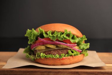 Ahşap masada lezzetli bir hamburger, yakın plan.