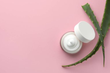 Pembe arka planda kremalı ve aloe yapraklı kavanoz, düz. Metin için boşluk