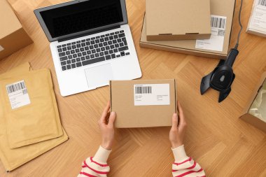 Ahşap masada paketli bir kadın var. Çevrimiçi mağaza