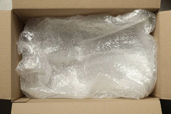 One open cardboard box with bubble wrap, top view