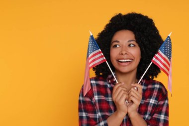 4 Temmuz - ABD 'nin Bağımsızlık Günü. Sarı arka planda Amerikan bayrakları olan mutlu kadın, mesaj için yer