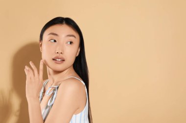 Bej arka planda güzel bir genç kadın, metin için boşluk