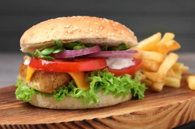 Tahta tahtada patates kızartmasıyla servis edilen lezzetli tofu burgeri, yakın plan.