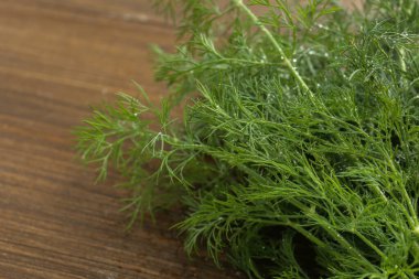 Taze yeşil dereotu ahşap masada, yakın plan.